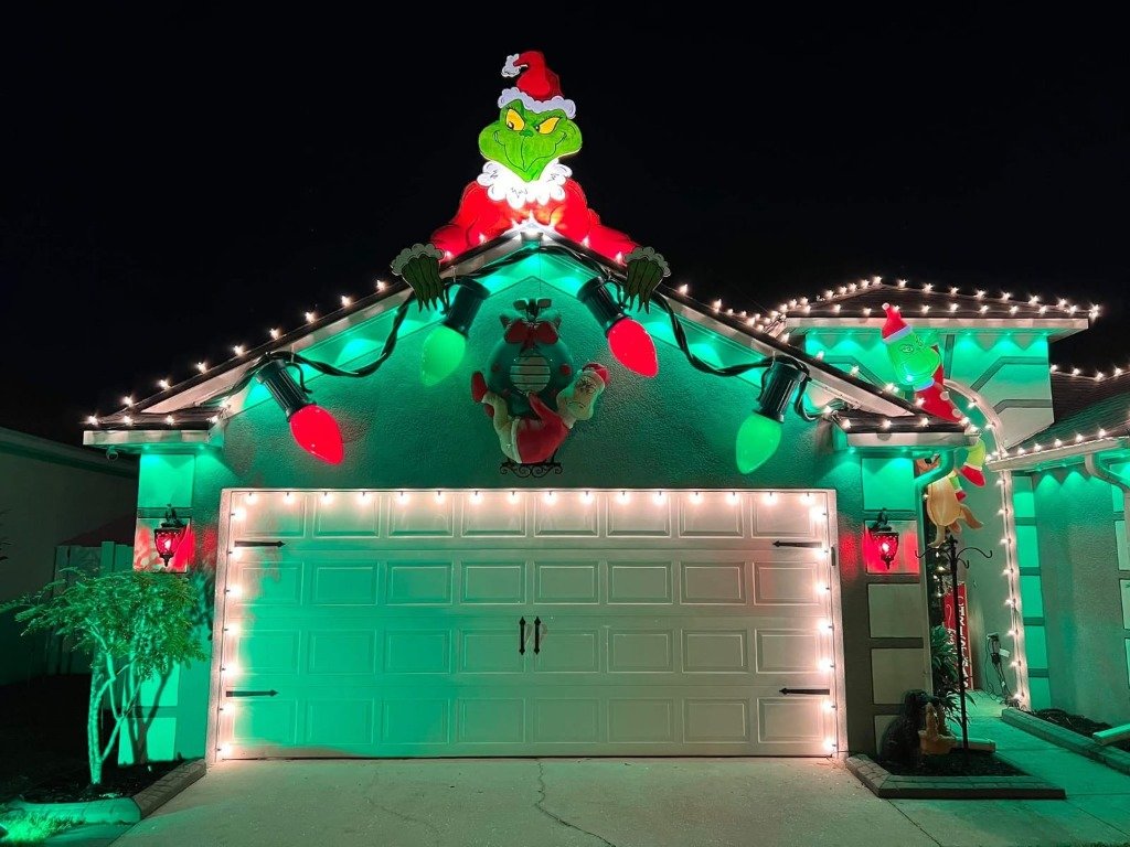 Grinch holiday themed rooftop and color wash lighting display